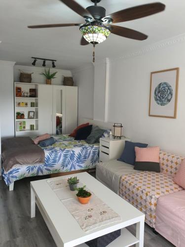 a living room with two beds and a ceiling fan at Playa del Ingles Estudio LOS MOLINOS 205 in Maspalomas