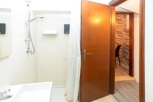 a bathroom with a shower and a wooden door at Giardino Giusti House & Court in Verona