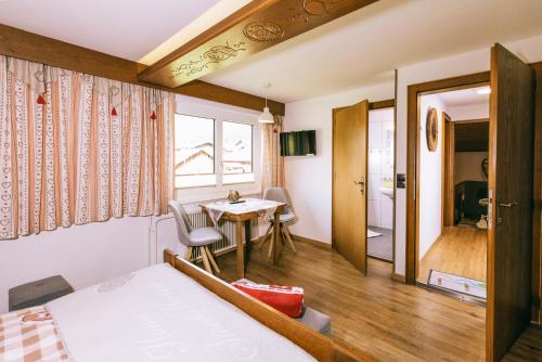 a bedroom with a bed and a table and chairs at Landhaus Perktold in Nesselwängle