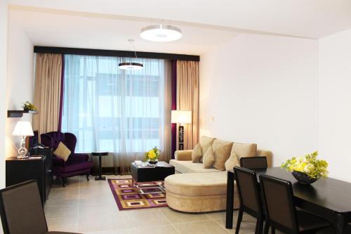 a living room with a couch and a table at Al Diar Sawa Hotel Apartments in Abu Dhabi