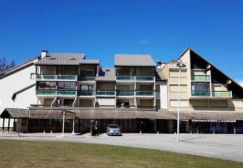 a building with a car parked in front of it at Superbe studio front de neige la joue du loup in Le Dévoluy