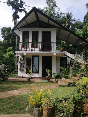 a house with a balcony on top of it at Riverston Nature Villa in Rattota
