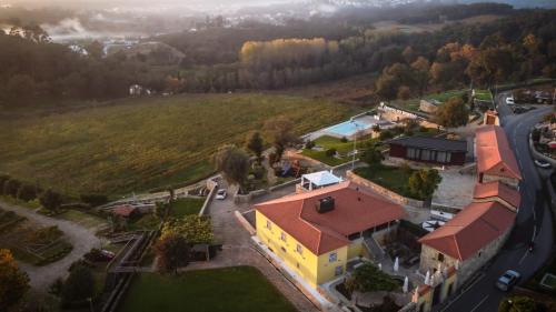 an aerial view of a small yellow building with a red roof at Quinta do Esquilo - Hotel Rural in Rendufe