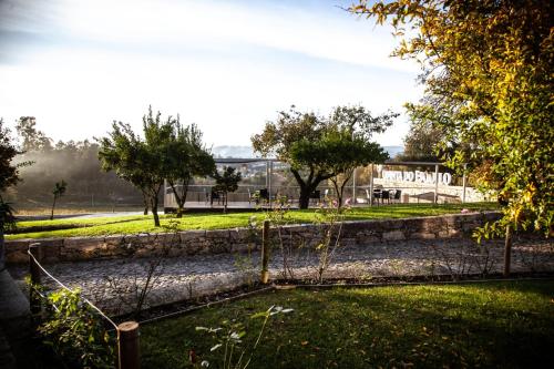 a park with a fence and trees and a building at Quinta do Esquilo - Hotel Rural in Rendufe