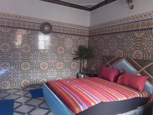 ein Schlafzimmer mit einem großen Bett in einem Zimmer mit Tapete in der Unterkunft Appart Artisanal BATHA Fez in Fès