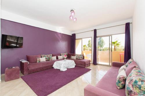 a living room with purple walls and purple couches at lafamilia in Marrakech