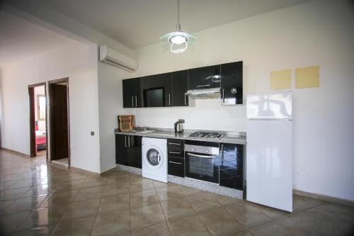 a kitchen with black cabinets and a stove top oven at lafamilia in Marrakech