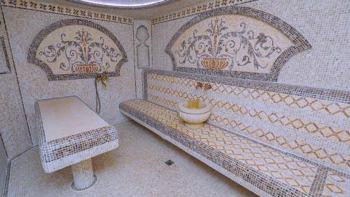a tiled bathroom with a toilet and a sink at MaxWell Hotel & SPA in Tashkent
