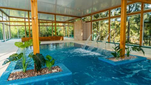 a pool in a glass house with a fountain at Villa Las Flores in Piriápolis