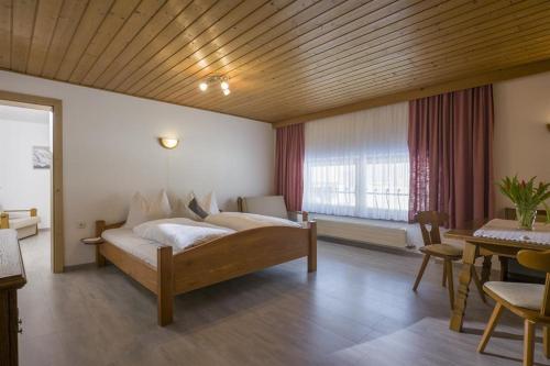 a bedroom with a large bed and a dining room at Bauernhof Hanslingerhof in Wörgl