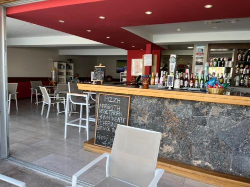 un restaurante con un bar con mesas y sillas blancas en Los Gracioseras 2 Bed Apt no 218 - AC, WIFI, UK TV, en Tías