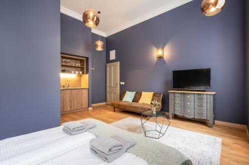 a room with a bed and a tv and a couch at The Pearl of the Heart of Budapest in Budapest