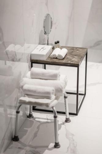 a table with a mirror and a chair with towels at VICTORIA Hotel Klaipėda in Klaipėda