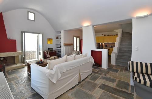 a living room with white couches and a kitchen at Villa Oliviers · Deluxe Villa - Infinity Pool & Helipad in Naousa