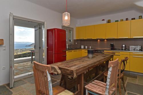 a kitchen with a wooden table and a red refrigerator at Villa Oliviers · Deluxe Villa - Infinity Pool & Helipad in Naousa