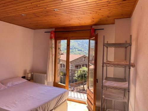 a bedroom with a bed and a window with a view at Cal Carbassó in Pardines