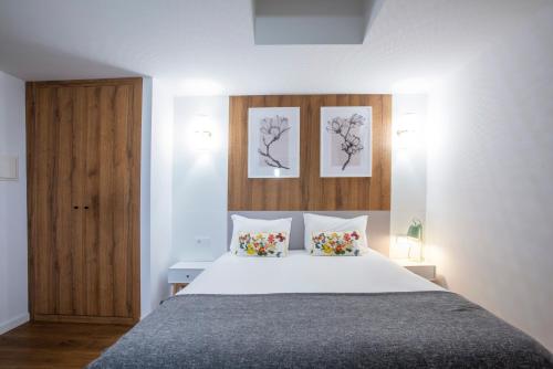 a bedroom with a bed and two pictures on the wall at Hotel Rural Solar das Arcadas in Ponte de Lima