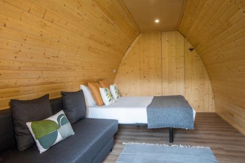 a room with a bed and a couch in a cabin at Hotel Rural Solar das Arcadas in Ponte de Lima