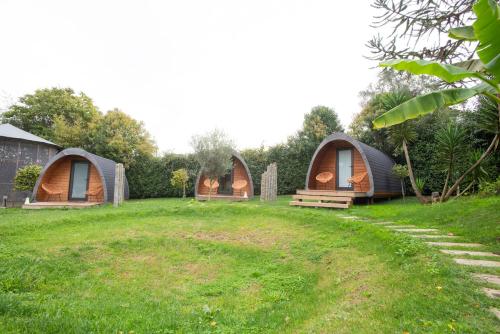 a group of three tents on a grass field at Hotel Rural Solar das Arcadas in Ponte de Lima