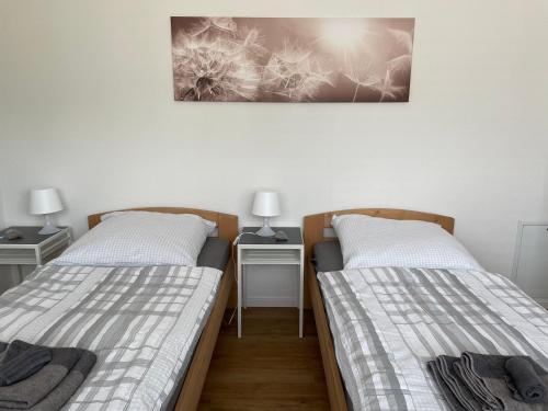 2 camas en una habitación con 2 mesas y 2 lámparas en Ferienhaus Simon, en Wadern