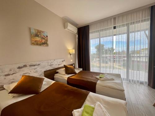 um quarto de hotel com duas camas e uma grande janela em Villa Amfora em Kranevo