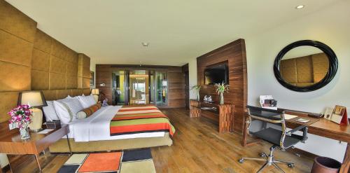 a bedroom with a bed and a desk and a mirror at The Lalit Chandigarh in Chandīgarh