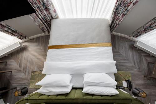 a bedroom with a bed with pillows at VICTORIA Hotel Klaipėda in Klaipėda