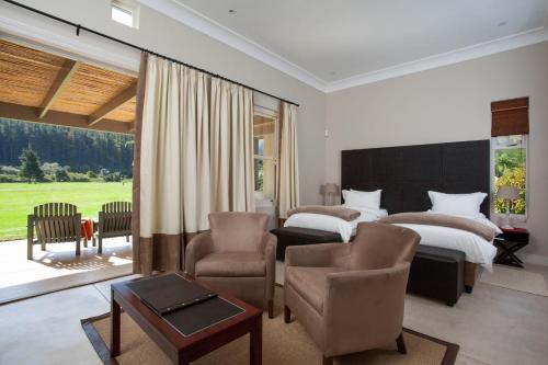 um quarto com 2 camas, uma mesa e cadeiras em Gaikou Lodge em Swellendam