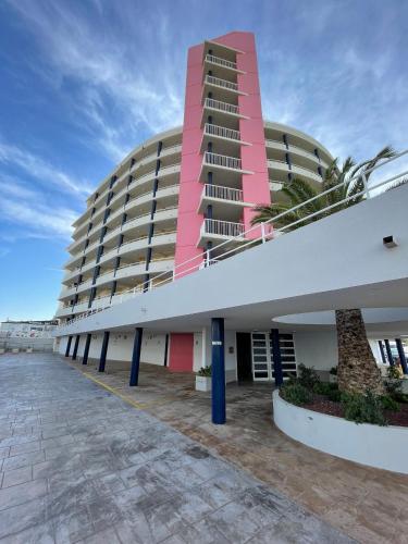 a large building with a pink and white building at Alpen1 Picasso in Peniscola