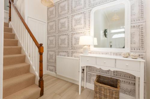 bagno con specchio e mobile con lavabo bianco. di Charles Alexander Short Stay - Rose Cottage a Lytham St Annes