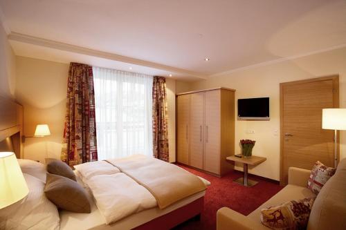 une chambre d'hôtel avec un lit et un canapé dans l'établissement Sonnblick Apartments und Zimmer - Nationalpark Sommercard inklusive, à Hollersbach im Pinzgau