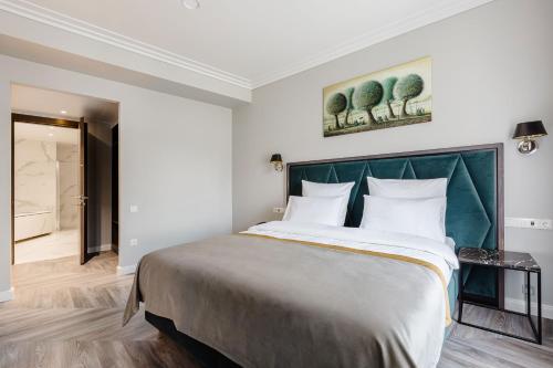 um quarto com uma cama grande e uma cabeceira verde em VICTORIA Hotel Klaipėda em Klaipėda