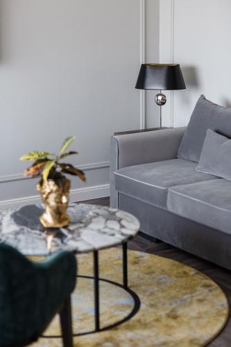 a living room with a couch and a table at VICTORIA Hotel Klaipėda in Klaipėda