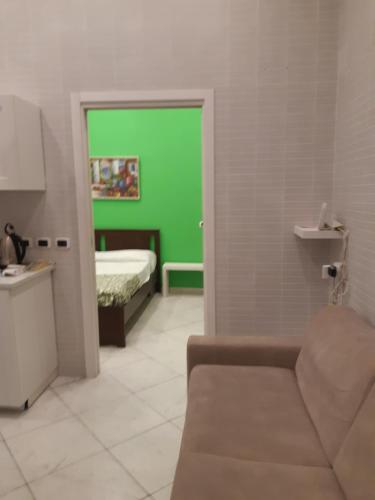 Cette chambre est dotée d'un mur vert et d'un lit. dans l'établissement Metropolis Stazione Centrale, à Naples