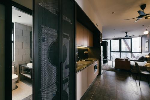 a kitchen with a sliding door to a living room at Scarletz KLCC Studio Suites 4 pax Luxury Modern Style WiFi 100Mbps in Kuala Lumpur