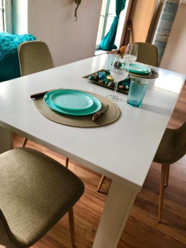 a white dining room table with plates and wine glasses at Brasov Cucu Residence in Braşov