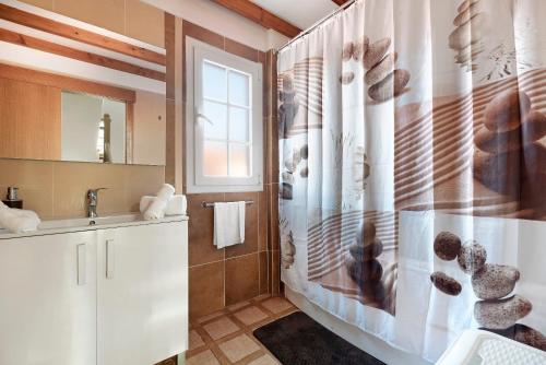 a bathroom with a shower curtain and a sink at Casa Luz in La Luz