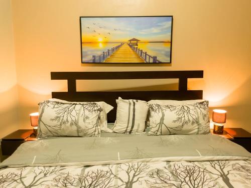 ein Schlafzimmer mit einem Bett und einem Gemälde eines Piers in der Unterkunft THEATRE OF DREAMS HOMES in Kampala