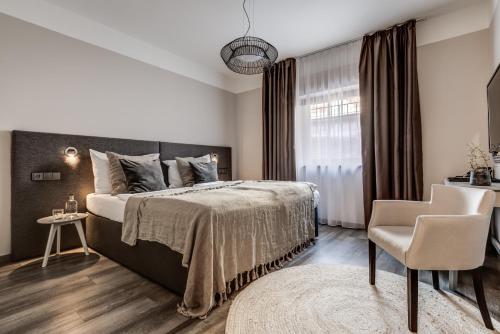 una camera con un grande letto e una sedia di Wellness Hotel Volarik a Mikulov