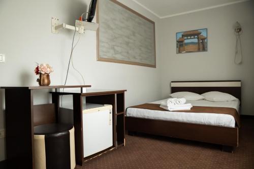 a hotel room with a bed and a desk at Pensiunea Lido Moisei in Moisei
