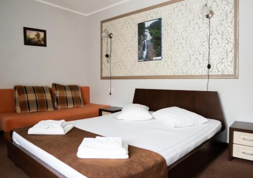 a hotel room with two beds and a couch at Pensiunea Lido Moisei in Moisei