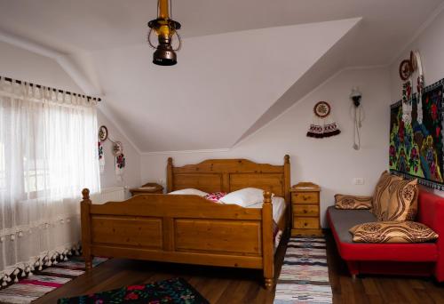a bedroom with a bed and a chair in a room at Pensiunea Lido Moisei in Moisei