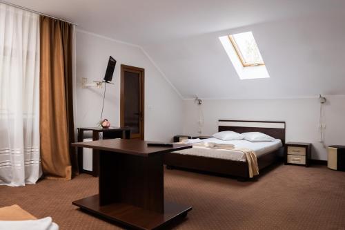 a bedroom with a bed and a desk in it at Pensiunea Lido Moisei in Moisei