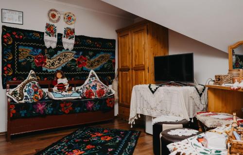 a living room with a couch and a tv at Pensiunea Lido Moisei in Moisei