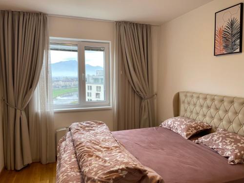um quarto com uma cama e uma grande janela em شقة نهر اليجا em Saraievo