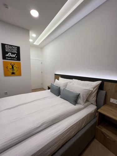 a bedroom with a large white bed with two pillows at OLYMPIC 84 Apartments in Sarajevo