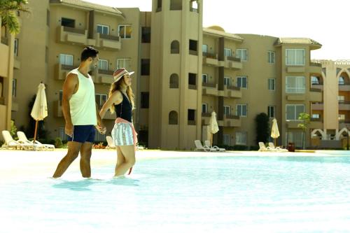 a man and a woman standing in the water at a resort at Marom Port Said Resort & Beach in Port Said