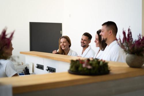 a group of people standing around a reception counter at Wellness Hotel Volarik in Mikulov