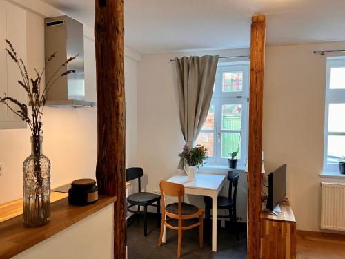 a living room with a table and chairs and a desk at Stella Apartments am Erfurter Dom in Erfurt