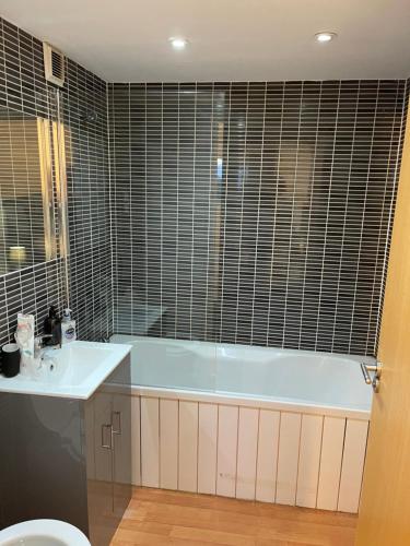 y baño con bañera y lavamanos. en Entire 2 bedroom Beautiful newly furnished flat en Glasgow